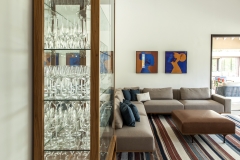 A lareira de ferro, com pintura de aço corten, e a cristaleira, desenhada exclusivamente para a família, são os charmes da sala de televisão